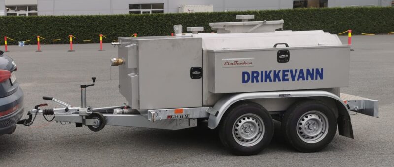 Vanntank på tilhenger med ScanWater-logo på. På parkeringsplass, tilkoblet bil.